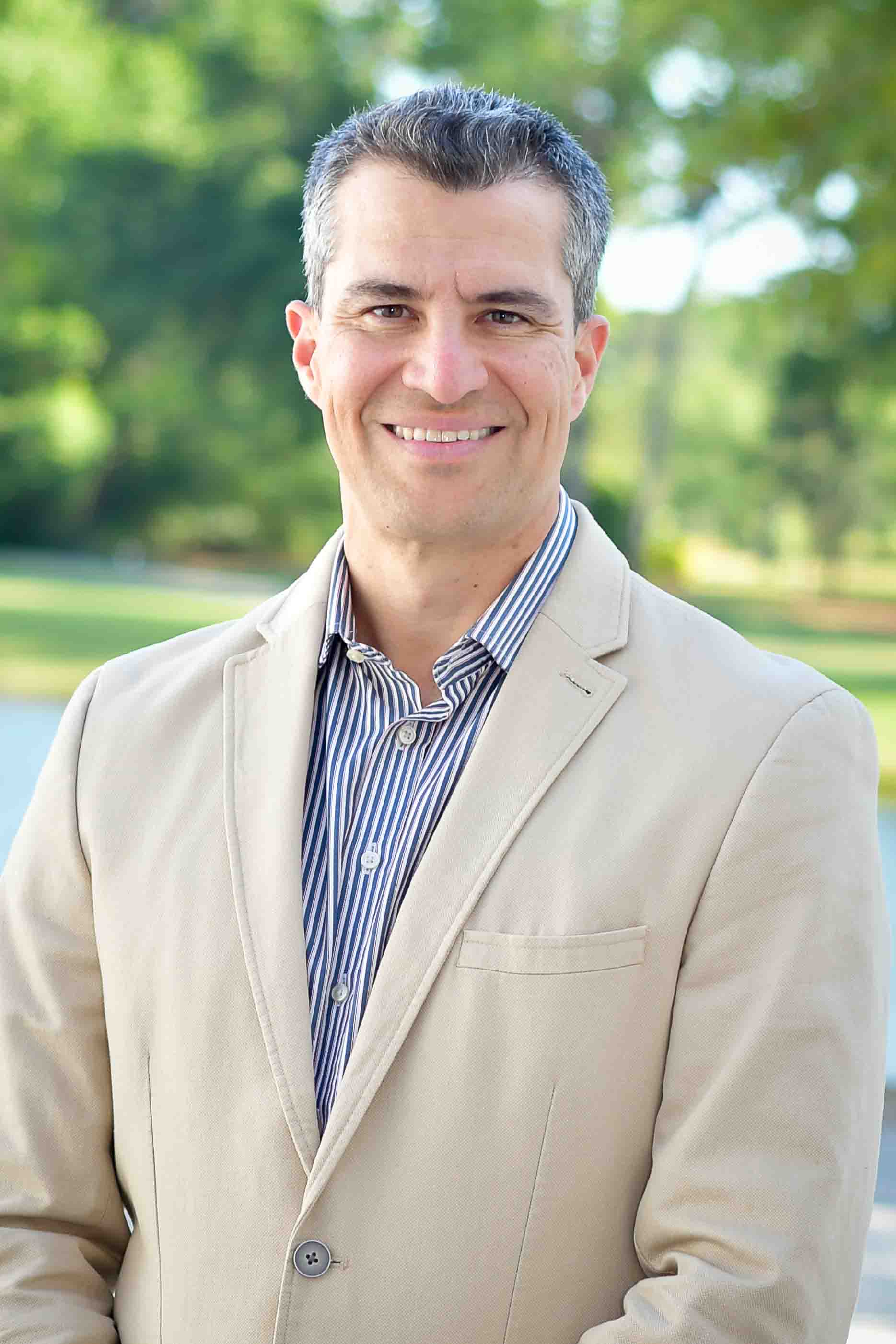 Outdoor portrait of Gustavo Flores-Macías who is smiling and facing the camera directly