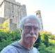 Tom Fox standing outside with a Gothic building behind him.