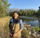 Wide shot of Sally Gibbons outdoors on a sunny day stranding near a creek